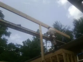 Carpenter setting a ridge beam over a new addition frame — Ice Dam Removal by Roofing Brothers in Nelsonville