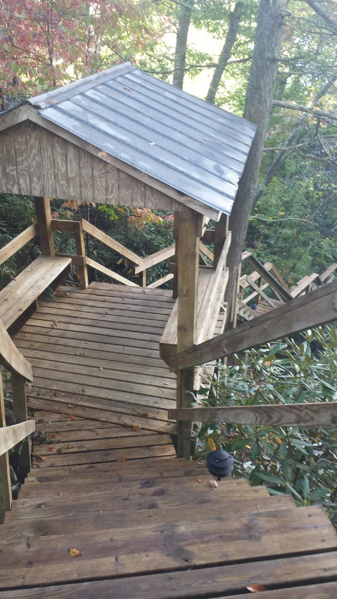 Metal roofed shelter over wooden steps on a wooded walkway — Skylight Repair & Installation work by our crew in Nelsonville