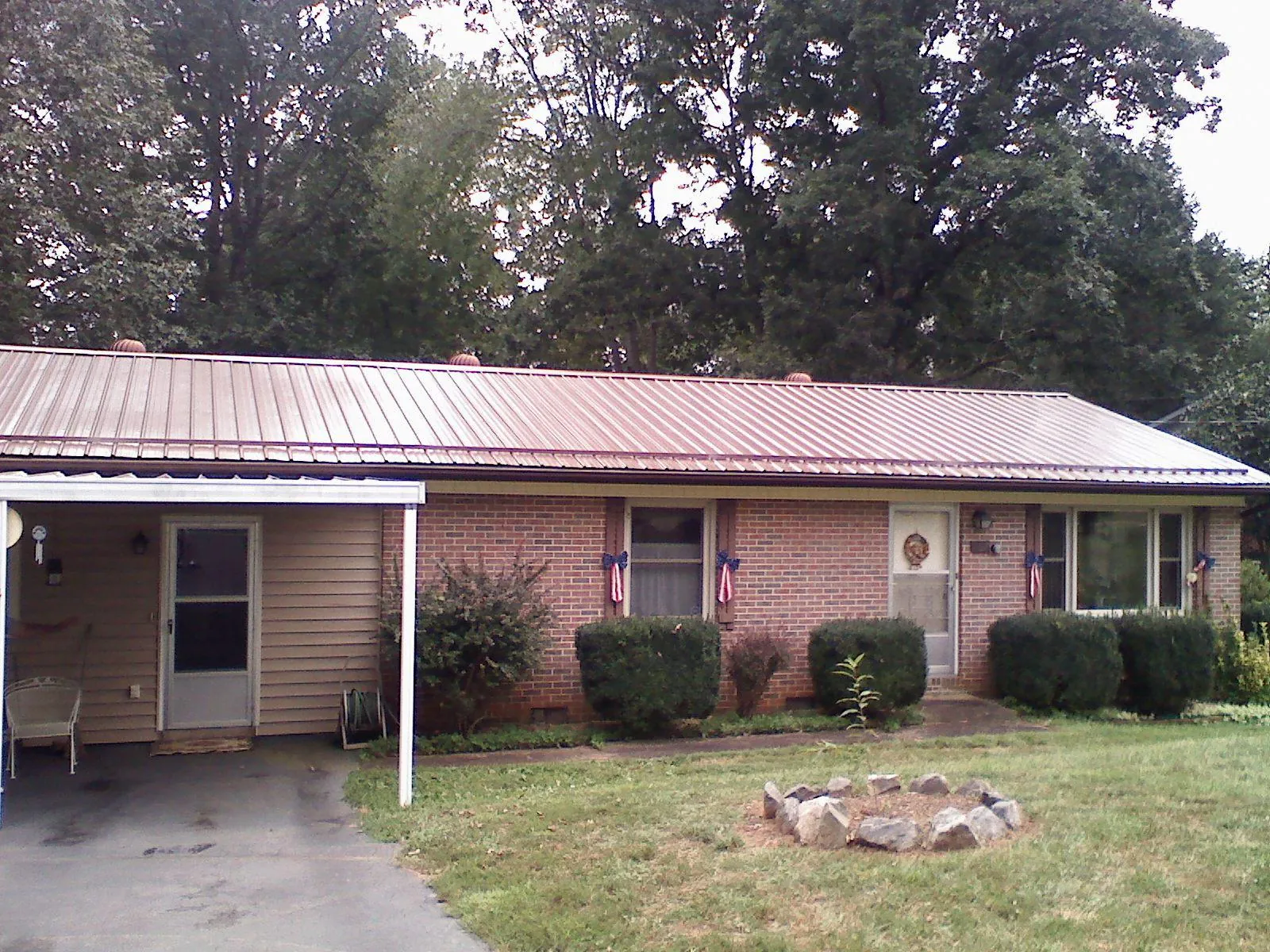 Bronze metal roof and carport on a brick ranch home — Roof Repair work by our crew in Nelsonville