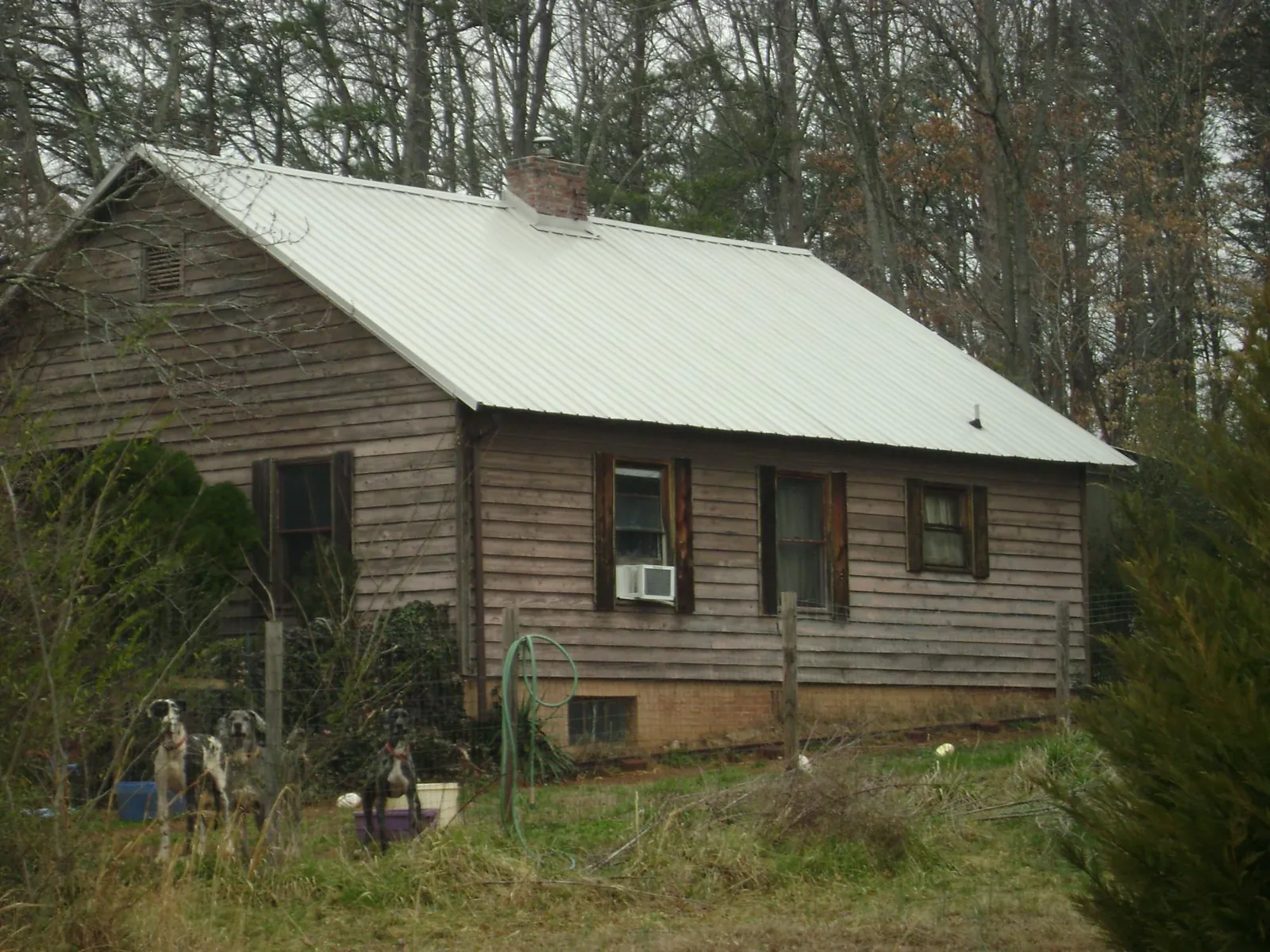 White metal roof on an old wood sided farmhouse, from a Metal Roof Installation job in Nelsonville